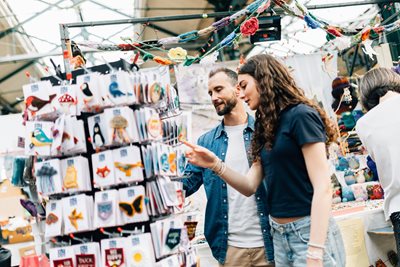 A man and woman browsing stalls at a market